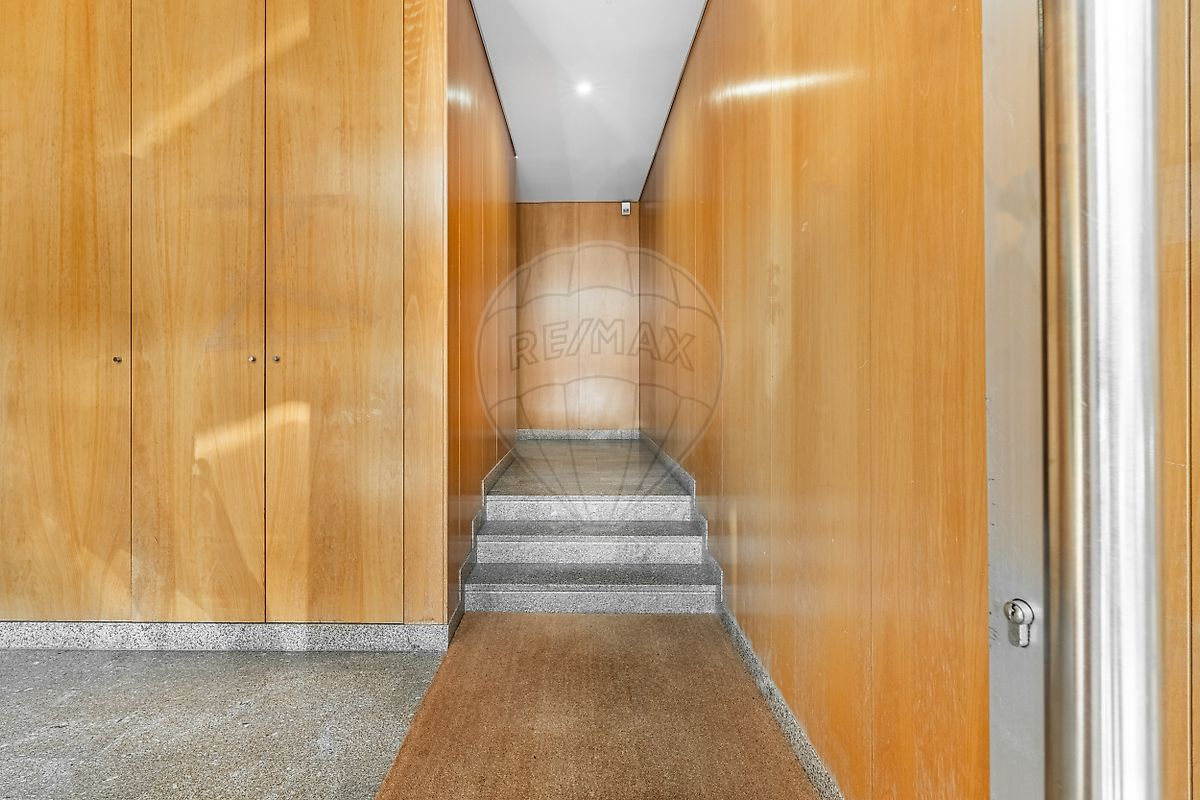 Hall de entrada do edifício com acabamentos em madeira e granito