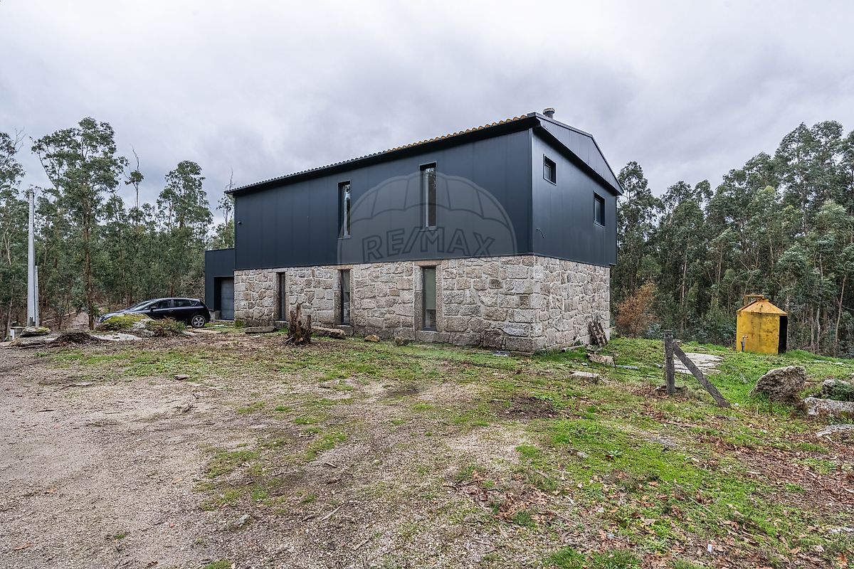 Fachada exterior da moradia com linhas modernas e portões de acesso