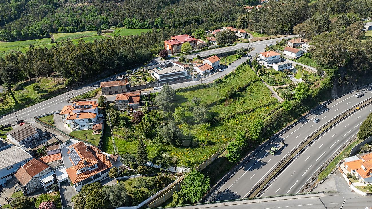 Vista aérea aproximada do terreno envolto por moradias residenciais e vias pavimentadas em Vila Nova de Famalicão