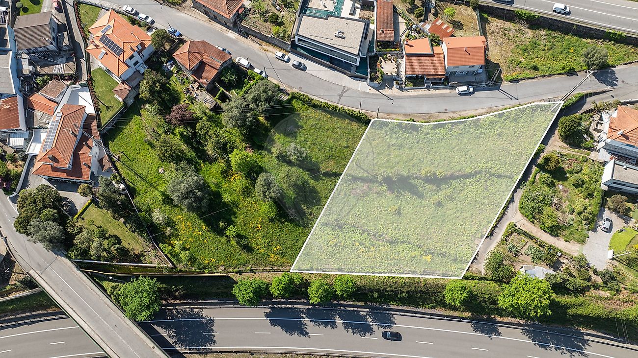 Fotografia de drone com realce translúcido sobre a totalidade do terreno para construção evidenciando a sua proximidade a acessos rodoviários principais