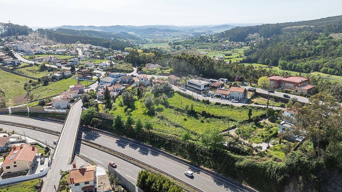 Perspetiva panorâmica de drone mostrando a excelente exposição solar do terreno e a proximidade ao viaduto e autoestrada no distrito de Braga