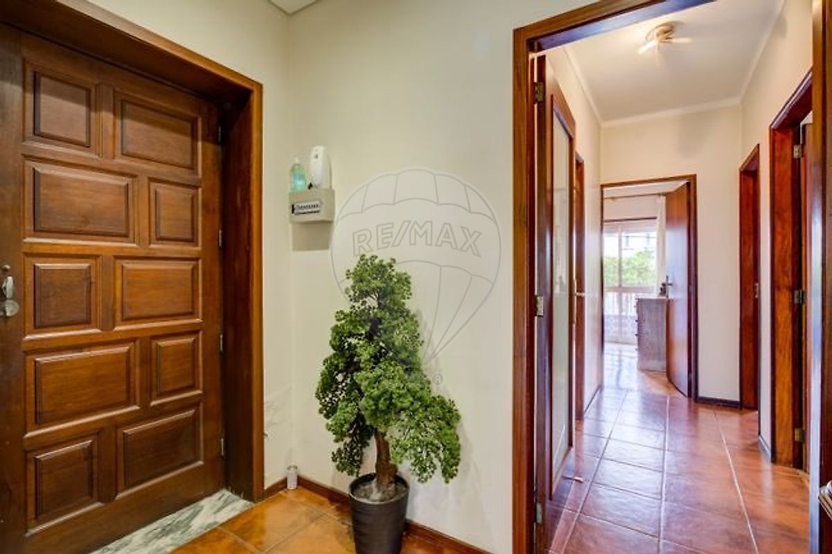 Hall de entrada do apartamento com porta em madeira maciça