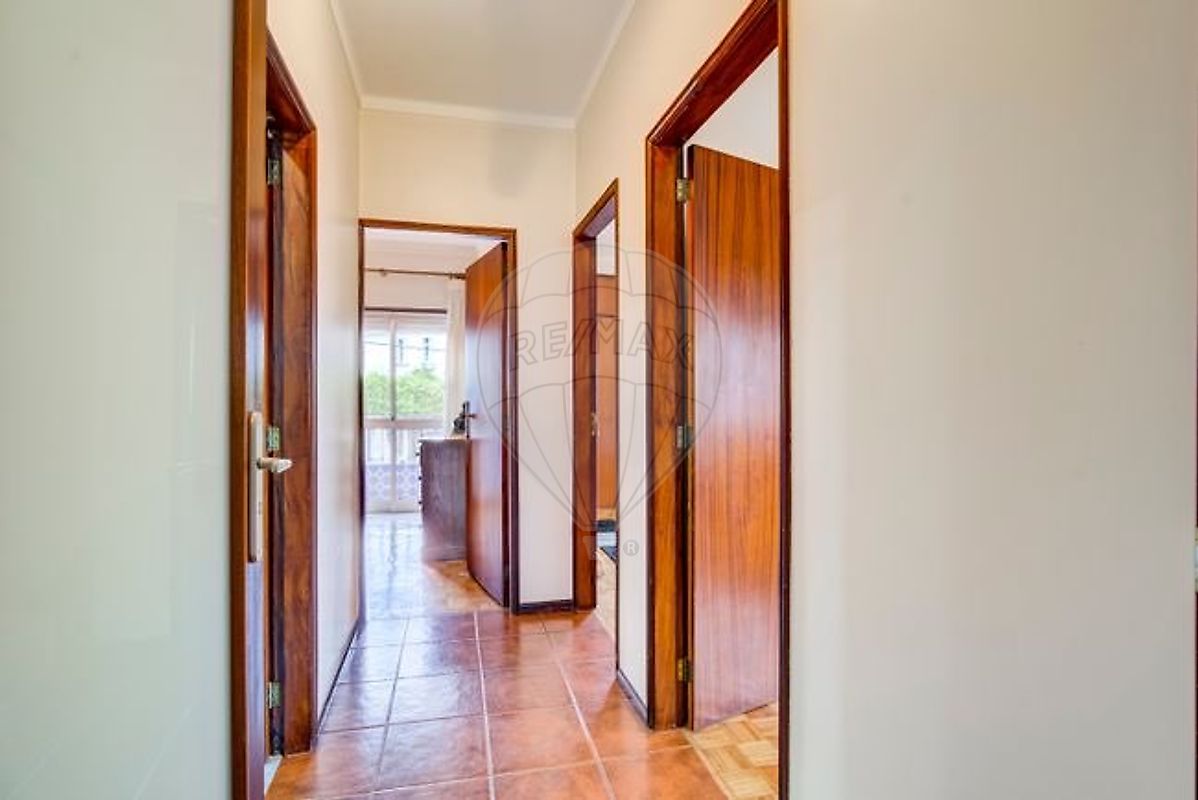 Detalhe do hall interior iluminado ligando as assoalhadas do apartamento T3