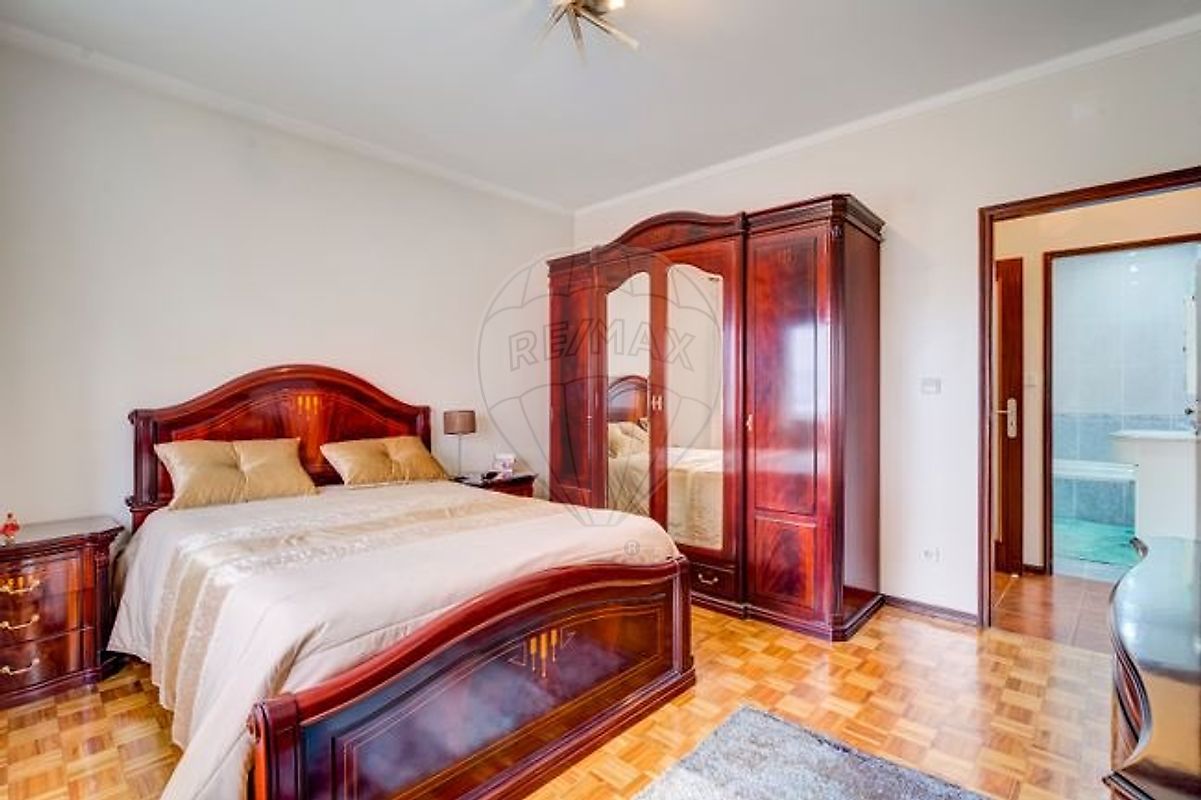 Quarto principal do T3 mobilado com cama de casal e roupeiro de grandes dimensões