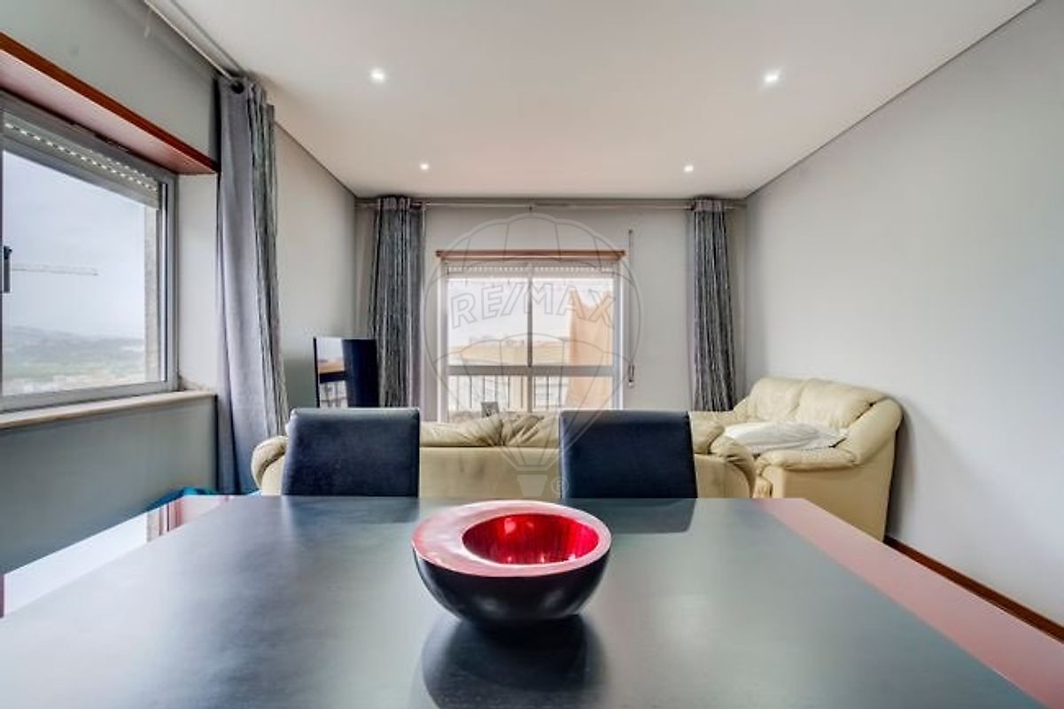 Sala de estar ampla e bem iluminada com mobiliário moderno e sofá extenso