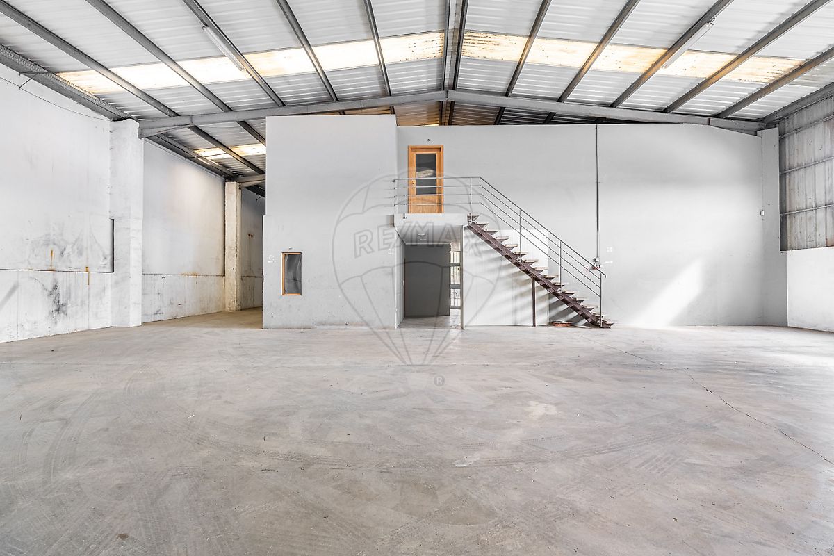Estrutura interior do pavilhão com escadaria de acesso a escritórios ou mezzanine administrativa integrada no armazém