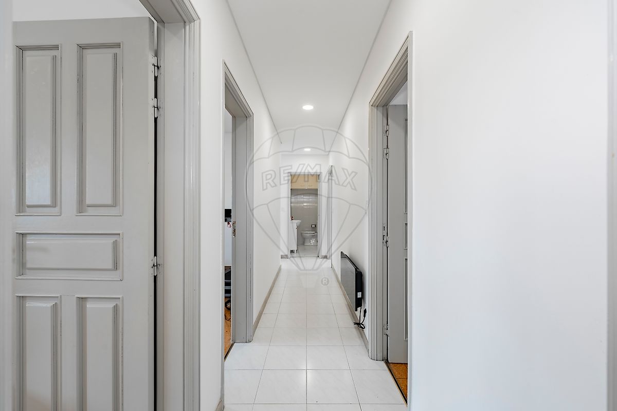 Corredor interior com iluminação moderna e acabamentos claros
