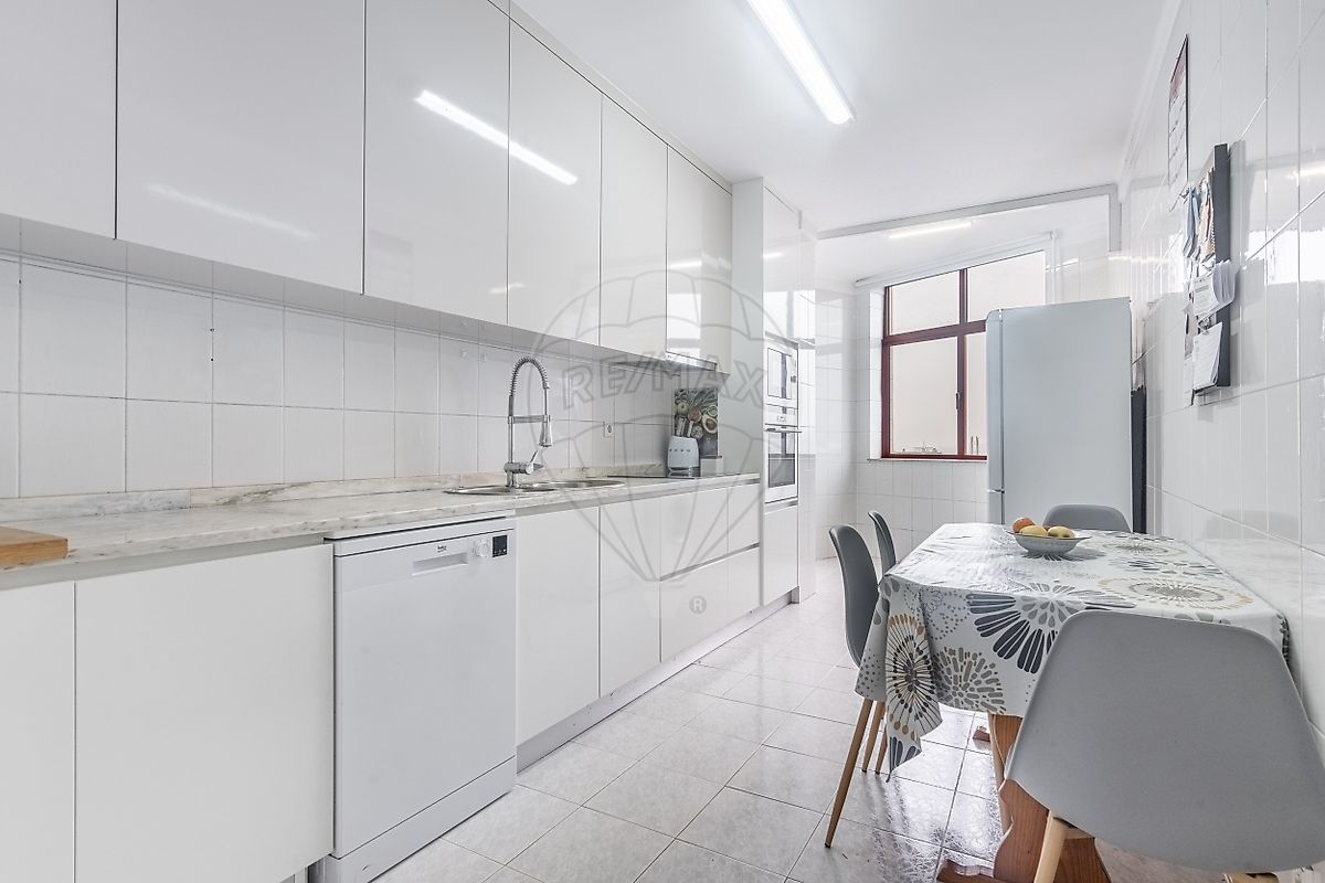 Cozinha moderna com armários lacados brancos brilhantes, totalmente equipada com bancada de refeições rápidas
