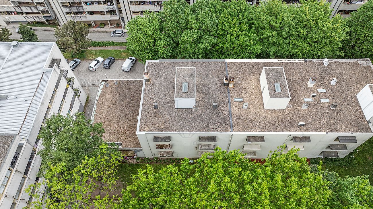 Vista de topo zenital do edifício residencial envolvido por paisagem arborizada em Guimarães