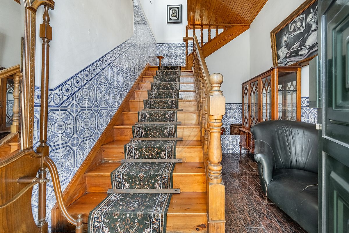 Escadaria em madeira com balaustrada torneada e azulejos azuis e brancos em moradia Fafe
