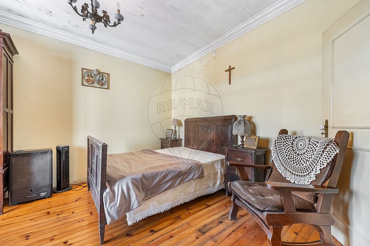 Quarto principal com cama de casal em ferro forjado e soalho em parquet em moradia T3 Fafe