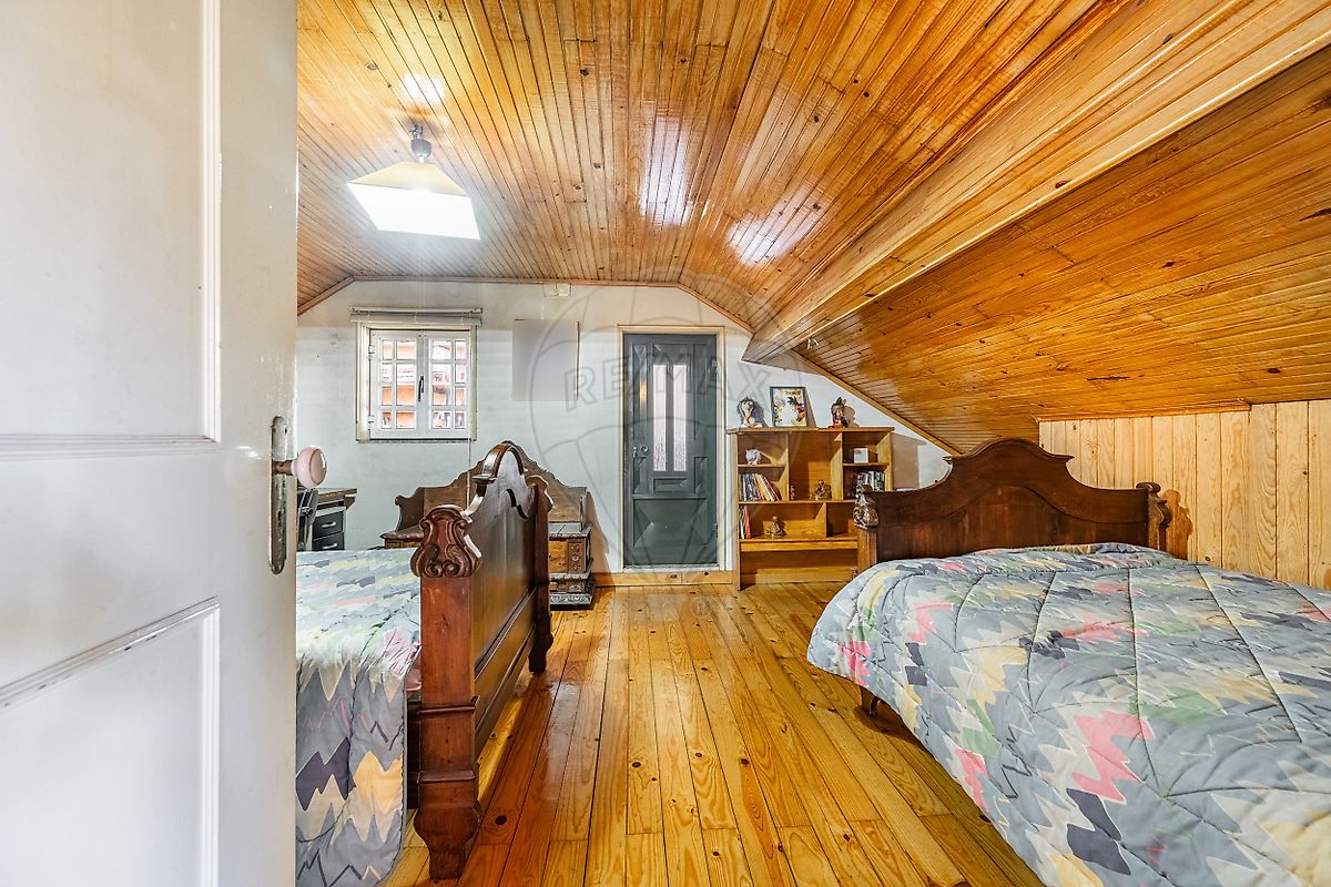Quarto com mobiliário antigo e janela com vista exterior em moradia T3 Fafe