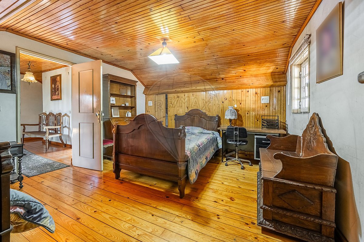 Quarto no sótão com teto em madeira e janela de claraboia em moradia Fafe