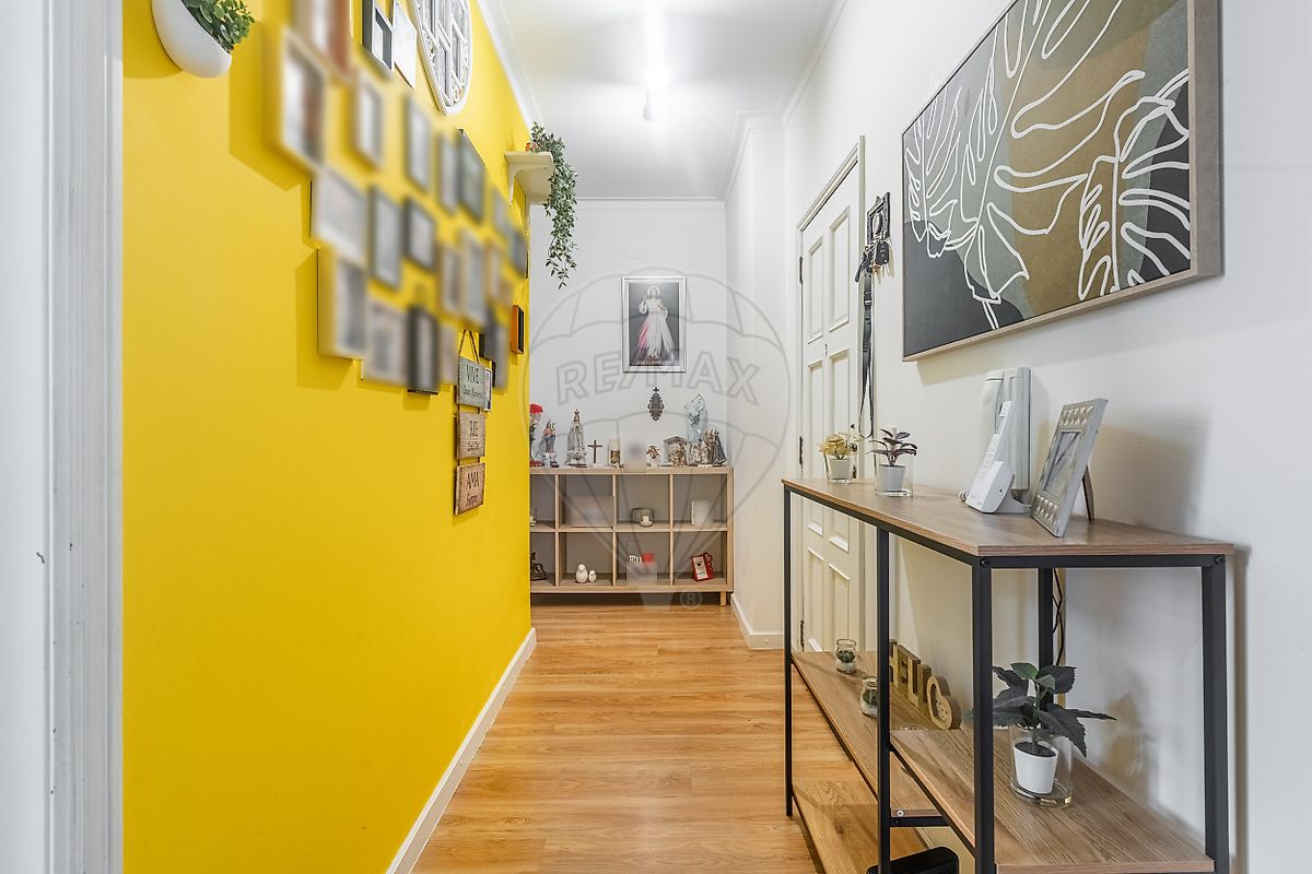 Hall de entrada acolhedor do apartamento T3 com acabamentos cuidados e pavimento flutuante
