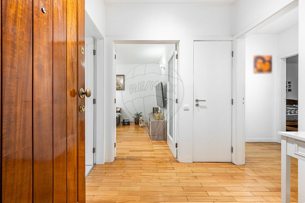Hall de distribuição e acesso aos quartos com roupeiros embutidos e pavimento em madeira