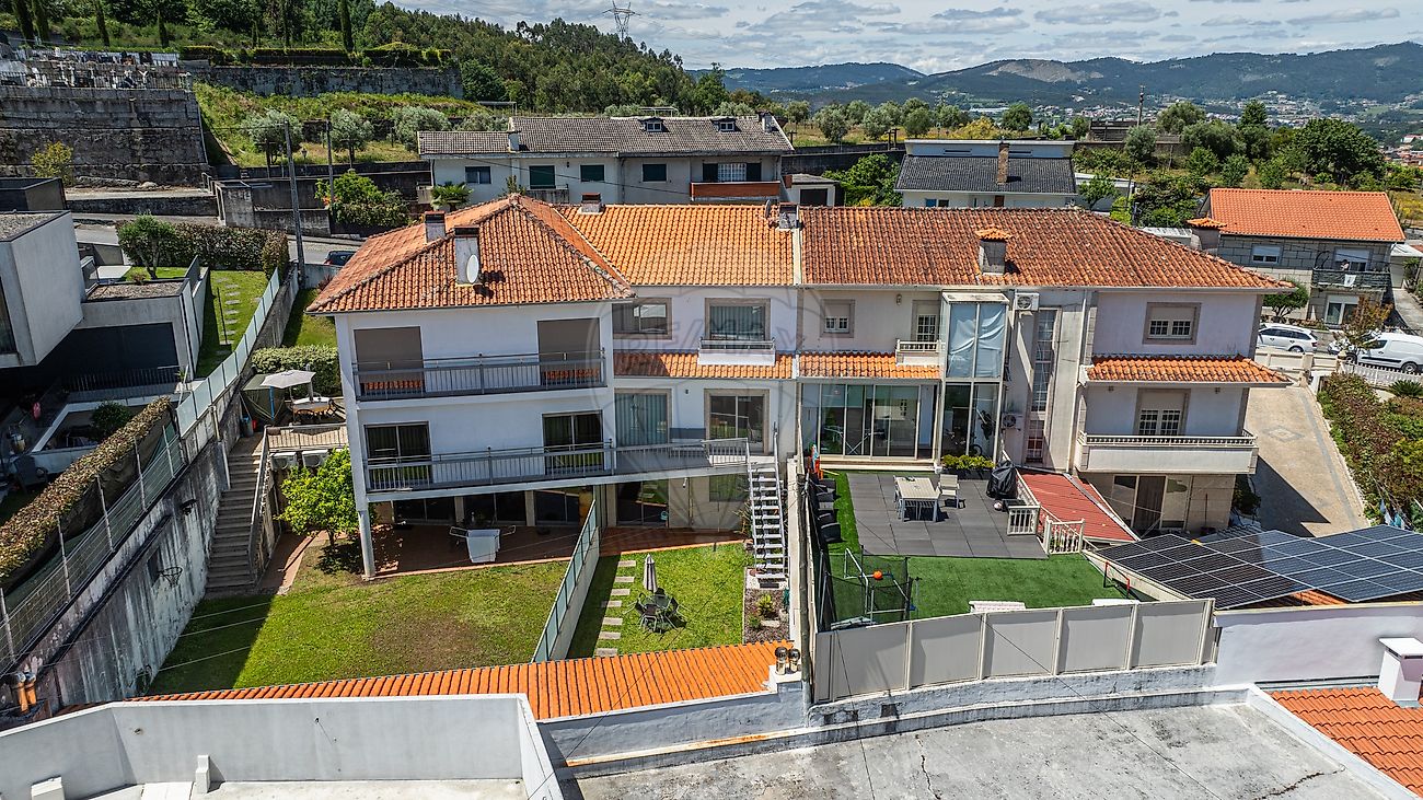 Zona de lazer exterior nas traseiras da moradia com relvado sintético e excelente exposição solar em Guimarães