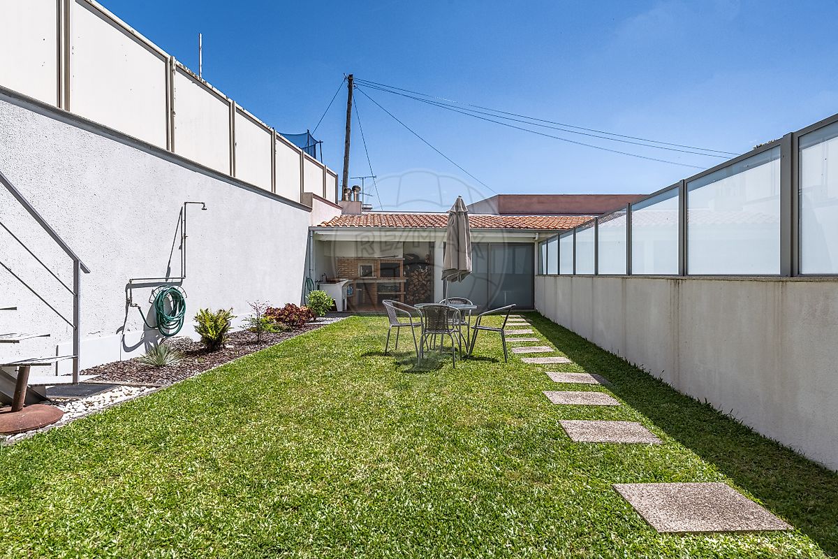 Vista detalhada do pátio exterior pavimentado na lateral da moradia em Guimarães
