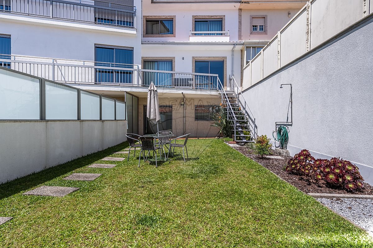 Perspetiva ampla do jardim relvado privativo nos fundos da moradia, ideal para lazer