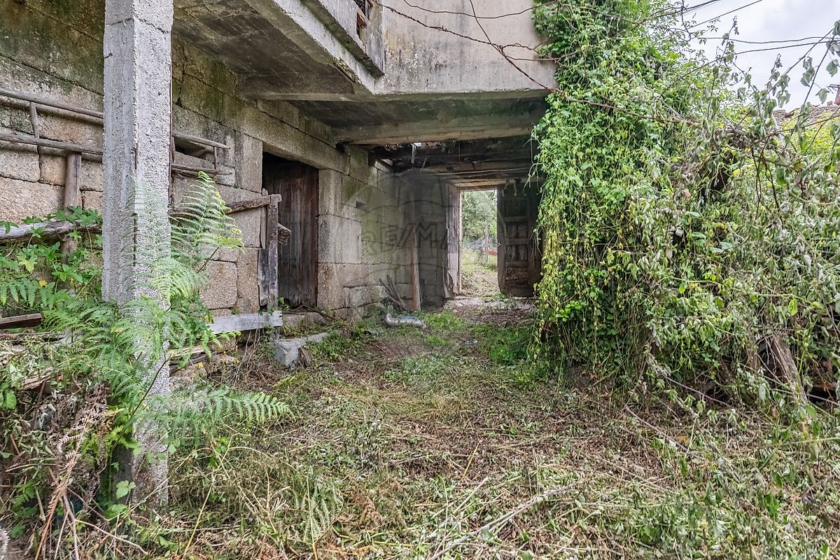 Pátio interno privativo delimitado por paredes de pedra rústica em moradia em Fafe