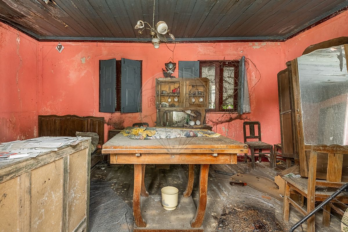 Amplo espaço interior com potencial para sala de estar em plano aberto com paredes em pedra exposta