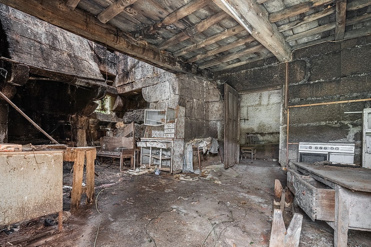 Vigas de madeira e arcos de pedra estruturais no interior de casa antiga em Fafe