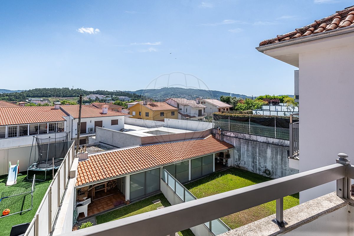 Varanda privativa com piso cerâmico e resguardo moderno virada para as traseiras e jardim