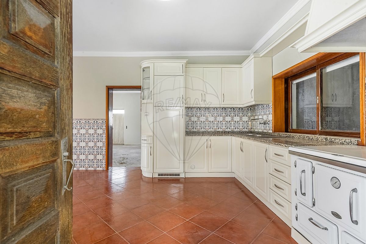 Perspetiva da bancada e espaço de arrumação da cozinha com potencial de modernização