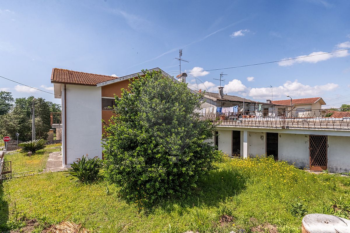 Espaço exterior ajardinado envolvente à casa, destacando a privacidade do terreno