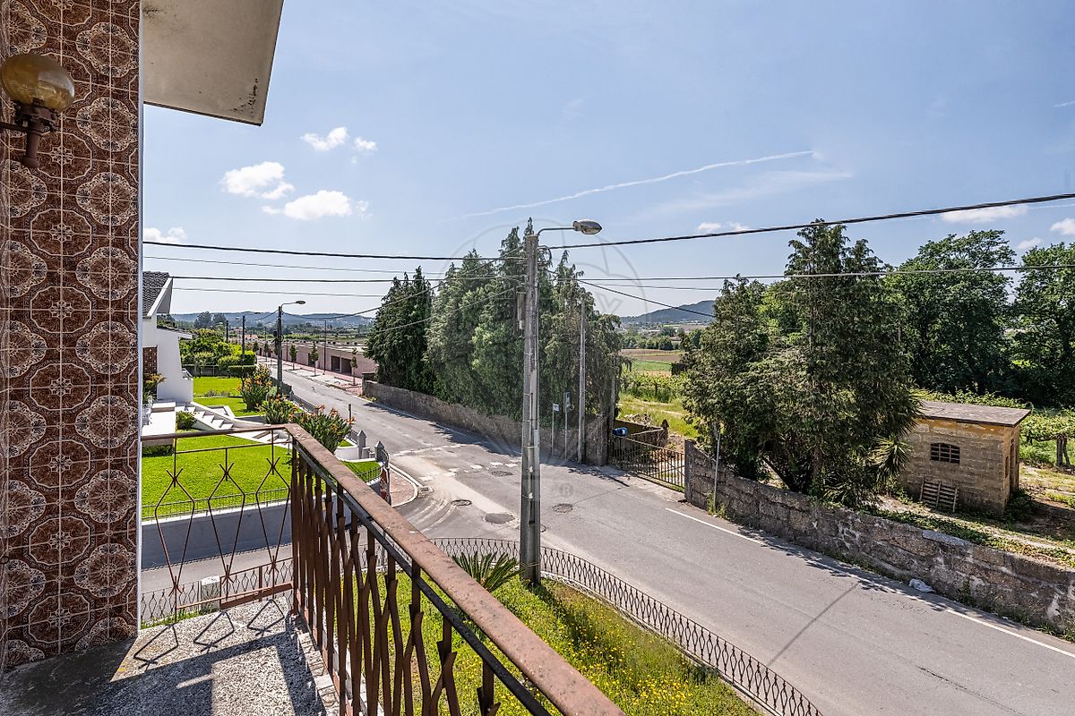 Varanda exterior corrida com guardas em ferro e vista para a envolvente residencial
