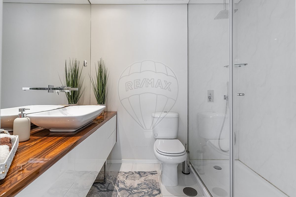 Casa de banho de apoio aos quartos completa com banheira, móvel de lavatório moderno e janela