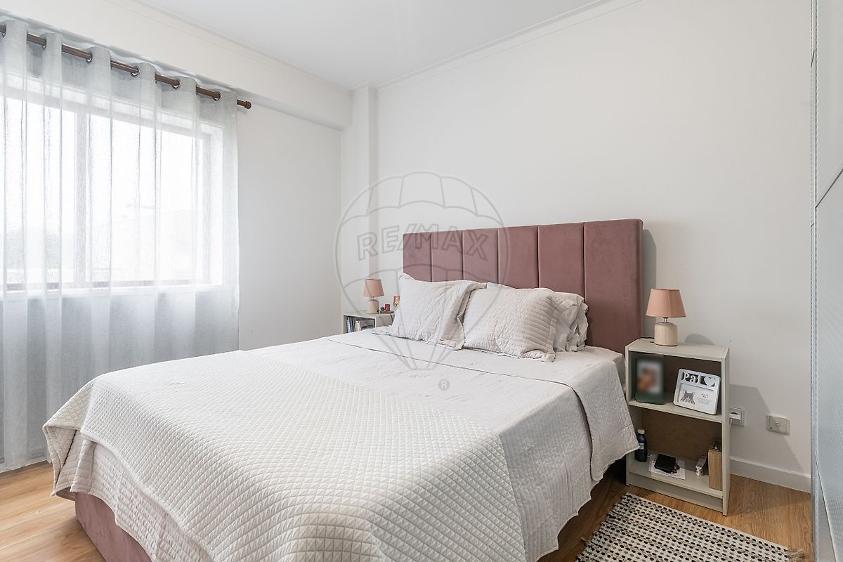 Quarto de casal principal decorado com cabeceira estofada rosa velho e roupeiro de grandes dimensões