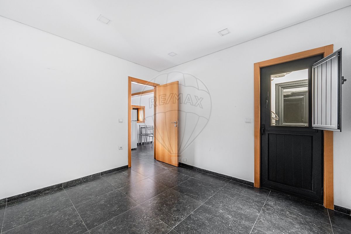 Espaço interior da moradia T1 com portas em madeira e acabamentos modernos