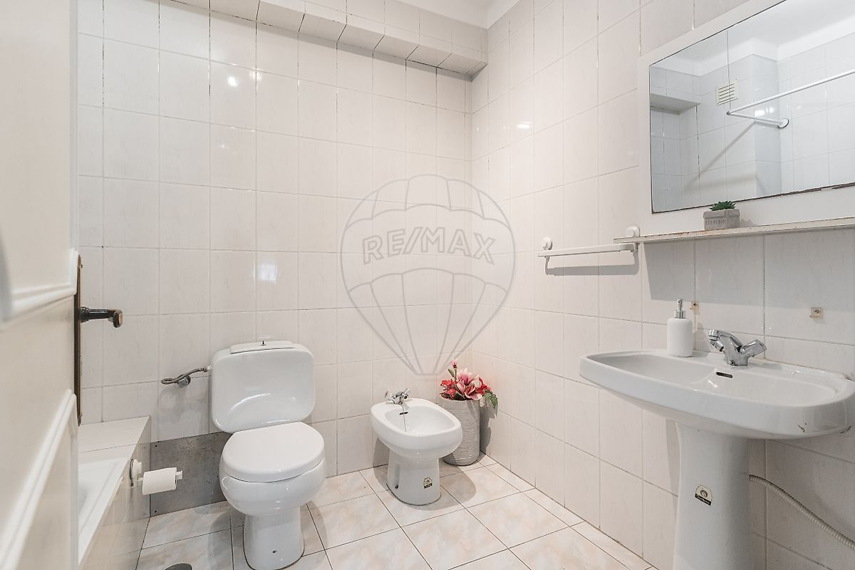 Casa de banho completa com banheira, loiças sanitárias suspensas modernas e espelho panorâmico